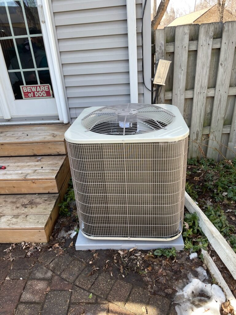 New AC condenser unit installed on concrete pad